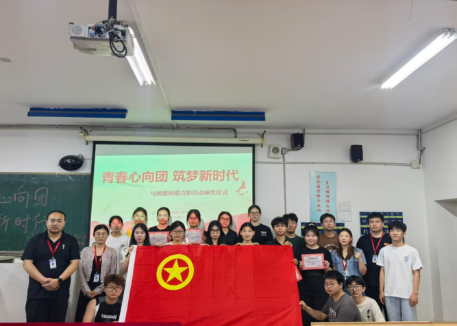 “青春心向团，筑梦新时代”与团旗团徽合影